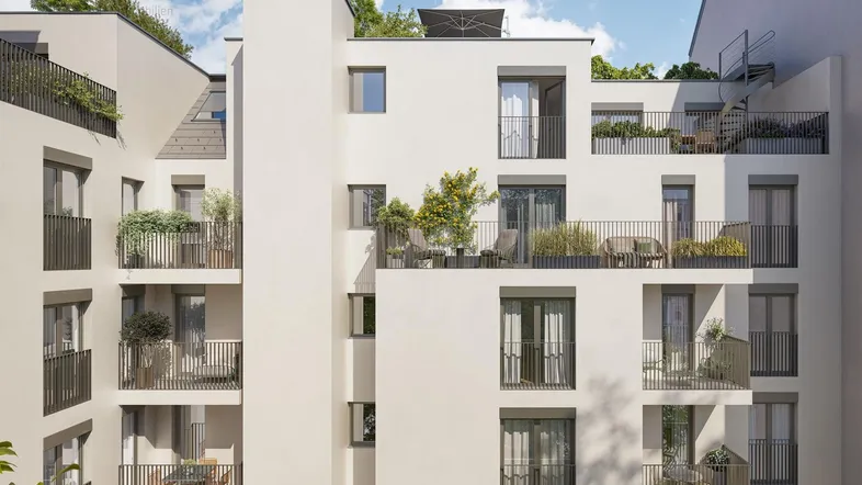 Moderne Wohnanlage mit mehreren Balkonen und begrünten Terrassen in urbaner Umgebung.