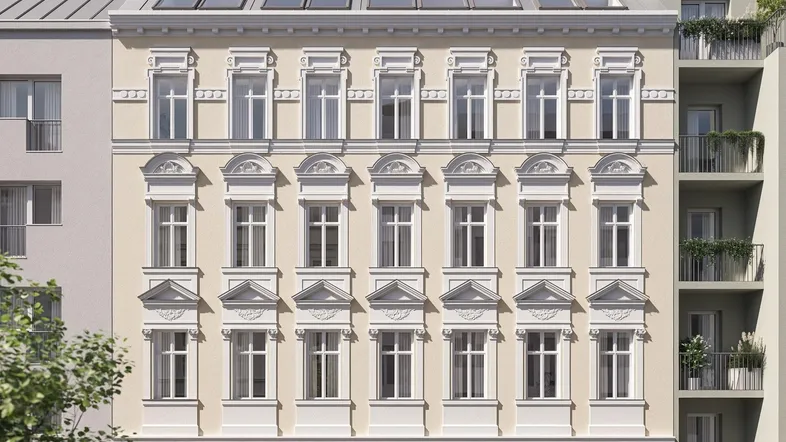 Klassische Fassade eines Mehrfamilienhauses mit Dachgauben und dekorativen Elementen.
