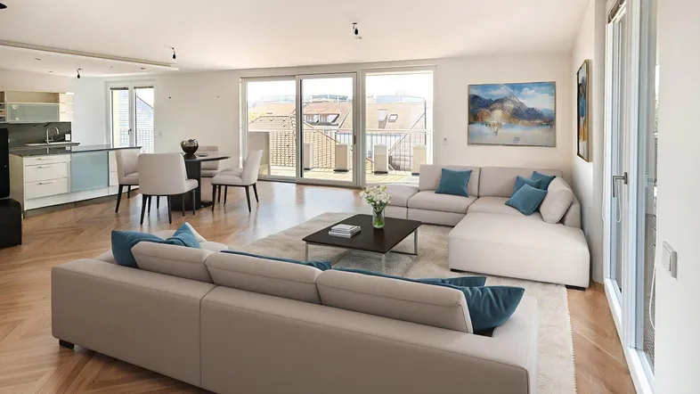 Helles, offenes Wohnzimmer mit Essbereich, moderner Küche und Zugang zur Terrasse.