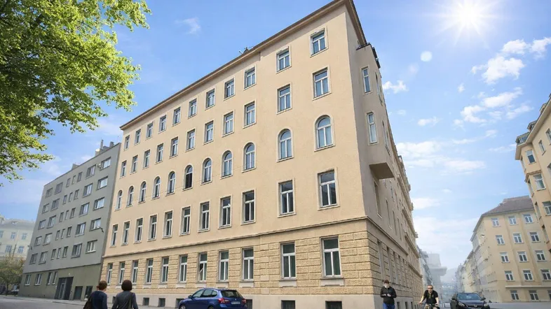 Historisches Eckgebäude mit klassischer Fassade und vielen Fenstern an einem sonnigen Tag.