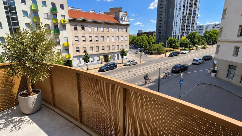 Geräumiger Balkon mit moderner Holzverkleidung und Blick auf die belebte Stadtstraße.