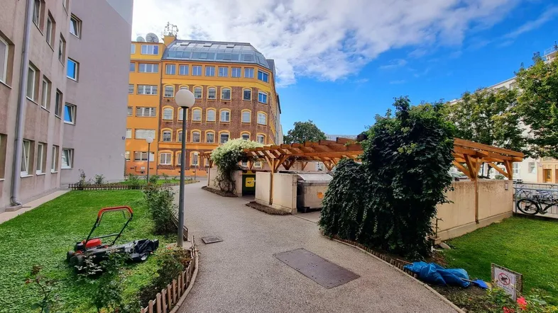 Gepflegter Gartenbereich zwischen Wohngebäuden mit Rasenfläche und Wegen.