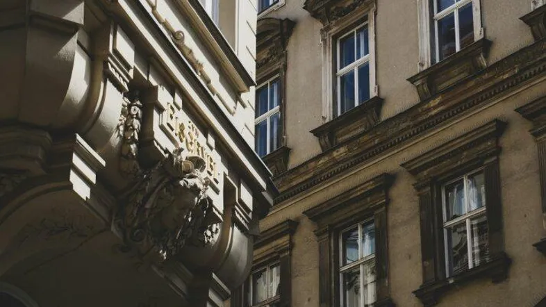 Historische Fassade eines Altbaus mit reich verzierten Fenstern und architektonischen Details in der Stadt.