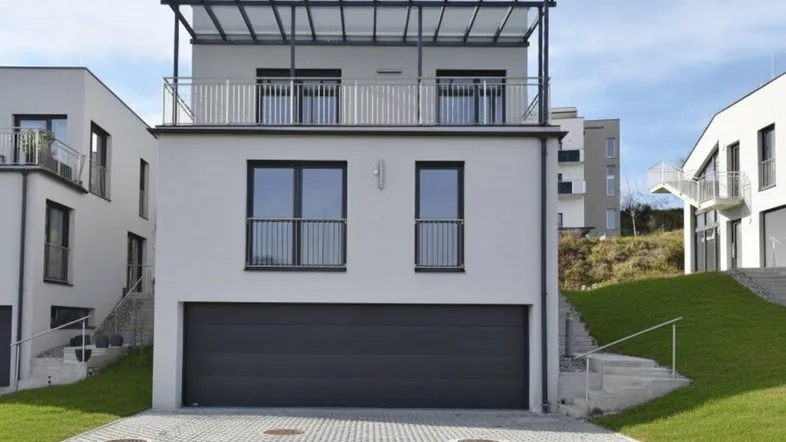 Moderne Neubau-Doppelhaushälfte mit integrierter Garage und überdachtem Balkon.