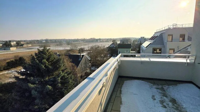 Geräumige Dachterrasse mit weitem Blick über die Landschaft und teilweise Schneeauflage.