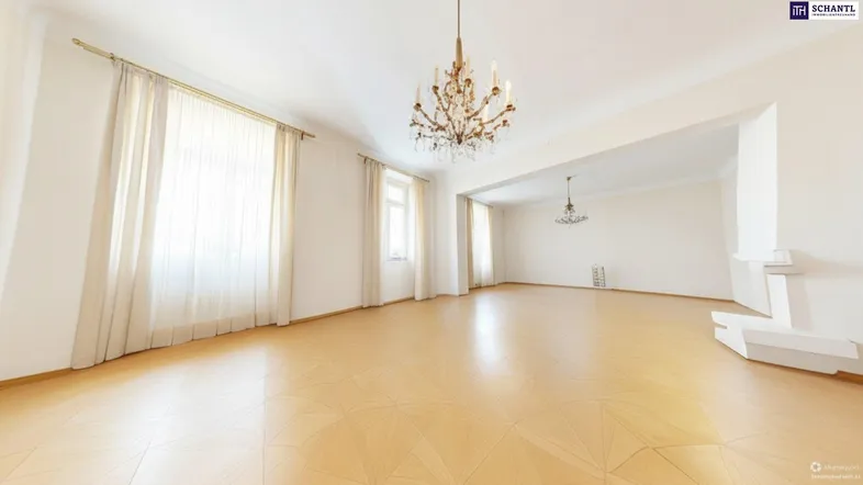 Helles und geräumiges Wohnzimmer mit elegantem Parkettboden und Kronleuchter.