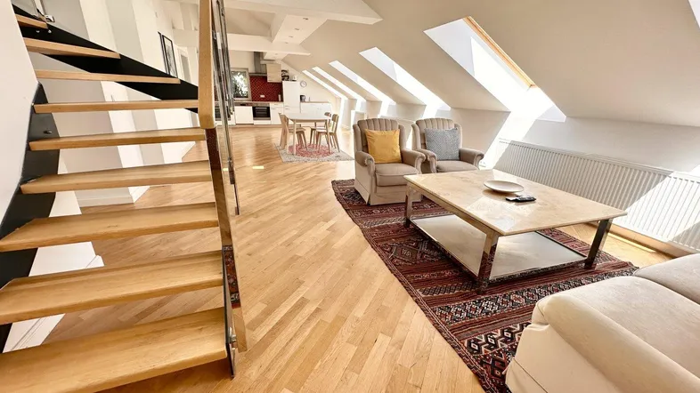 Helles, offenes Dachgeschoss mit Parkettboden, Wendeltreppe und integrierter Küche.
