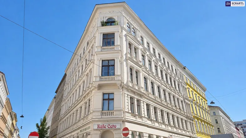 Historisches Eckgebäude mit klassischer Architektur, Stuckfassade und vielen Fenstern.