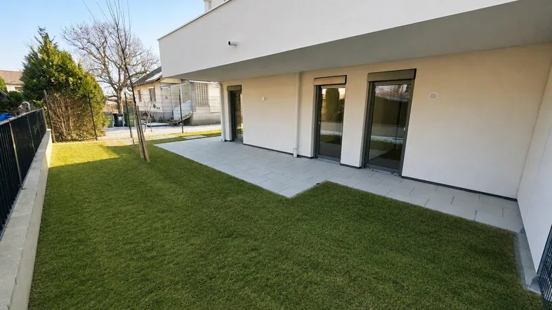 Moderner Neubau mit gepflegtem Gartenbereich und großer Terrasse für entspannte Stunden im Freien.