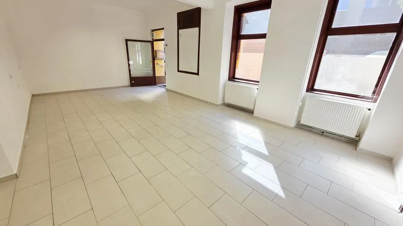 Heller, leerer Raum mit weißen Wänden und Fliesenboden, ideal für ein Büro oder Geschäft.
