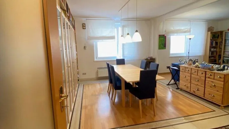 Geräumiger Wohn- und Essbereich mit Holzboden und Fliesen, ideal für gesellige Abende.