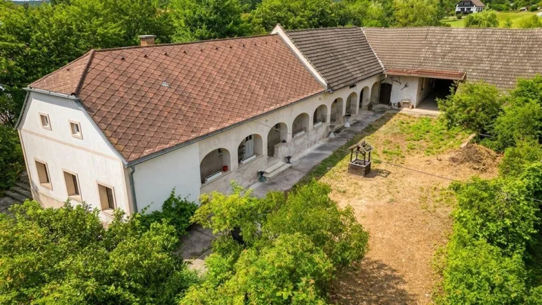Luftaufnahme des Anwesens mit mehreren Gebäuden und einem großen, ungenutzten Innenhof.