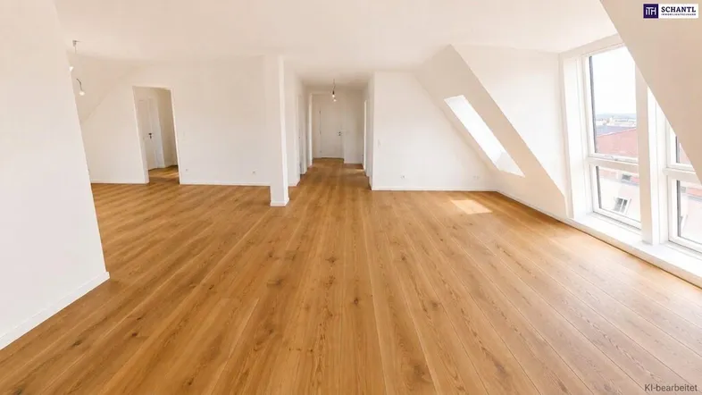 Helles, geräumiges Wohnzimmer im Dachgeschoss mit Holzboden und großen Fenstern.