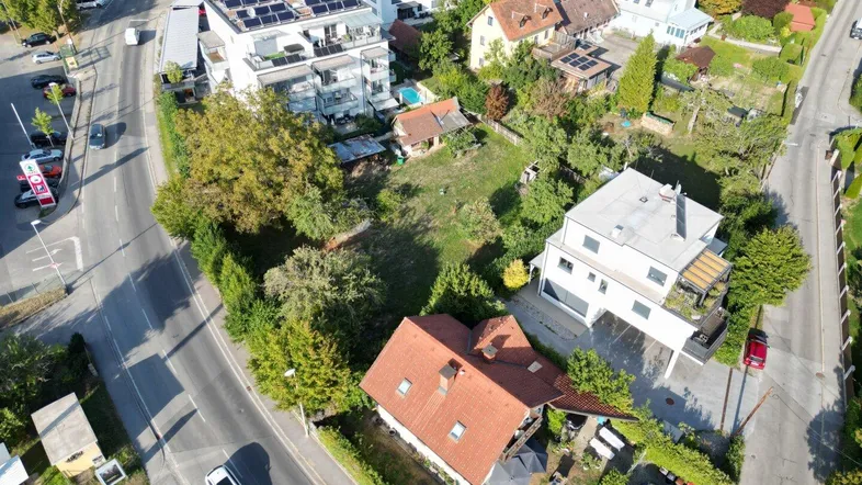 Luftaufnahme eines Wohngebiets mit mehreren Häusern, Straßen und viel Grünfläche.