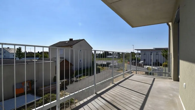 Geräumiger Balkon mit Metallgeländer und Blick auf die umliegende Wohngegend.