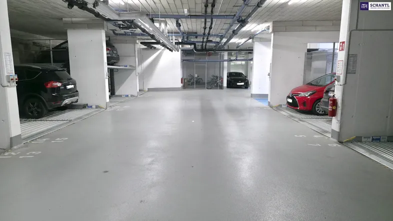 Geräumige Tiefgarage mit automatischen Parksystemen und mehreren Stellplätzen für Fahrzeuge.