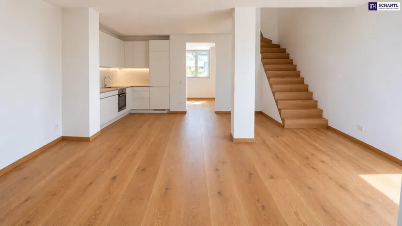 Heller offener Wohn-Essbereich mit integrierter Küchenzeile und Holztreppe, ideal für modernes Wohnen.