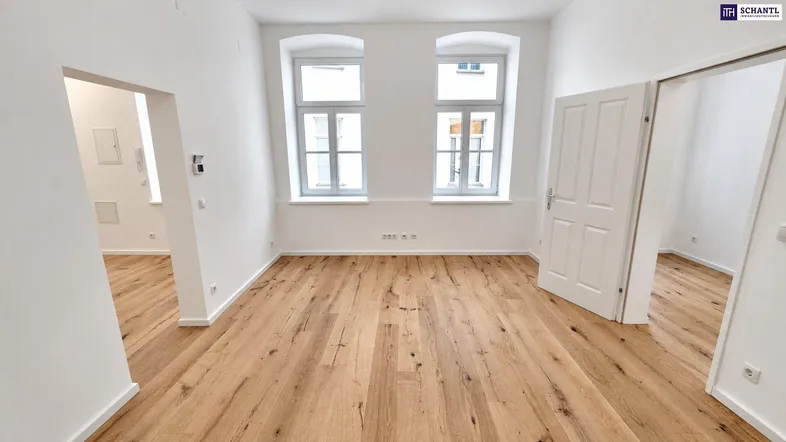 Helles Zimmer mit neuem Holzboden und zwei Fenstern, bereit zur individuellen Gestaltung.