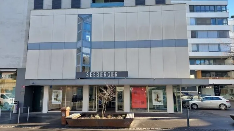 Moderne Geschäftsfassade mit großen Schaufenstern und dem Schriftzug "SEEBERGER" in der Stadt.