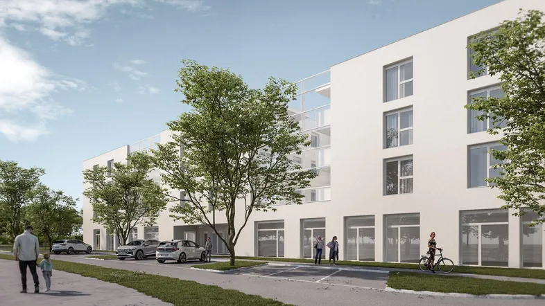 Moderne Architektur eines neuen Gebäudes mit großen Fenstern, umgeben von Bäumen und Parkplätzen.