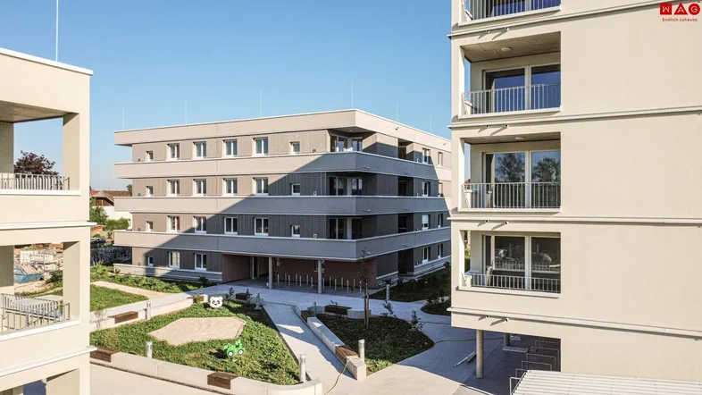 Moderne Wohnanlage mit mehreren Gebäuden und begrüntem Innenhof mit Spielplatz.