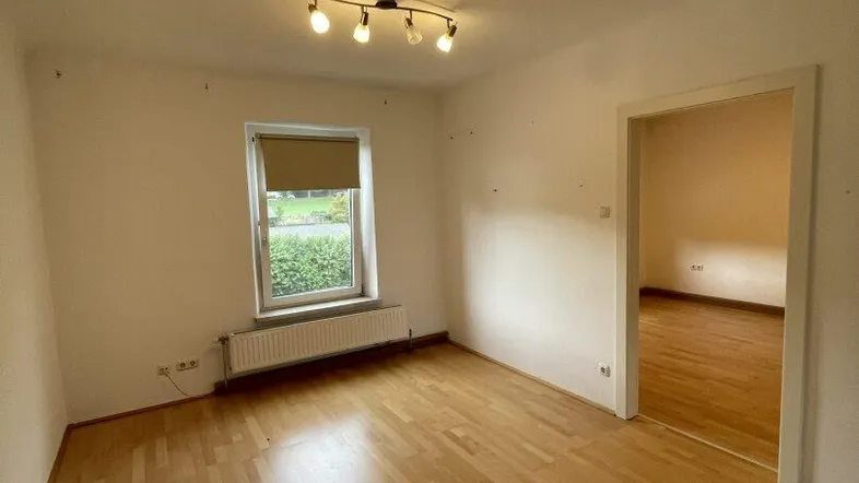 Heller Raum mit Parkettboden und Fenster, bereit zur individuellen Gestaltung.