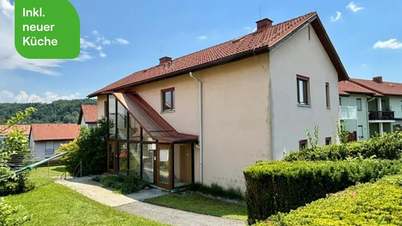 Gepflegtes Einfamilienhaus mit Wintergarten, Satteldach und großem Garten in ländlicher Umgebung.