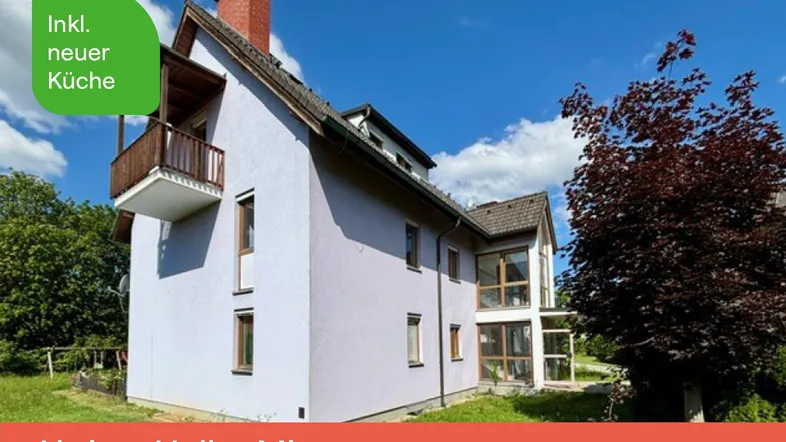 Freistehendes Haus mit Balkon und Garten in ländlicher Umgebung unter blauem Himmel.