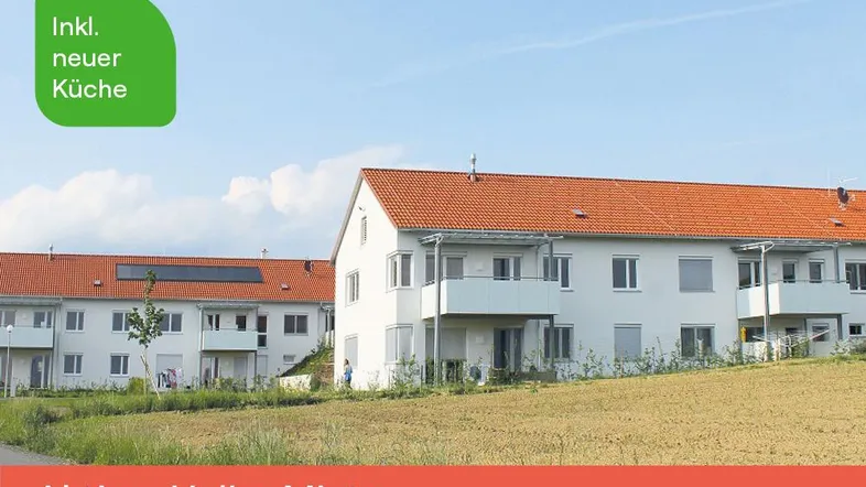 Mehrere moderne Wohngebäude mit roten Ziegeldächern und Balkonen in ländlicher Umgebung mit weitem Blick.