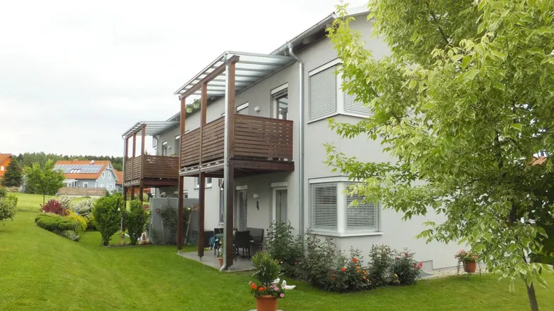 Modernes Reihenhaus mit gepflegtem Garten, Terrasse und Balkonen in ruhiger Wohnlage.