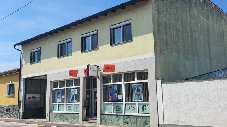 Fassade eines Gebäudes mit Ladenlokal im Erdgeschoss und Wohnungen darüber.