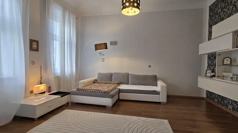 Helles Wohnzimmer mit modernem Sofa, Teppich und dekorativer Wandgestaltung.