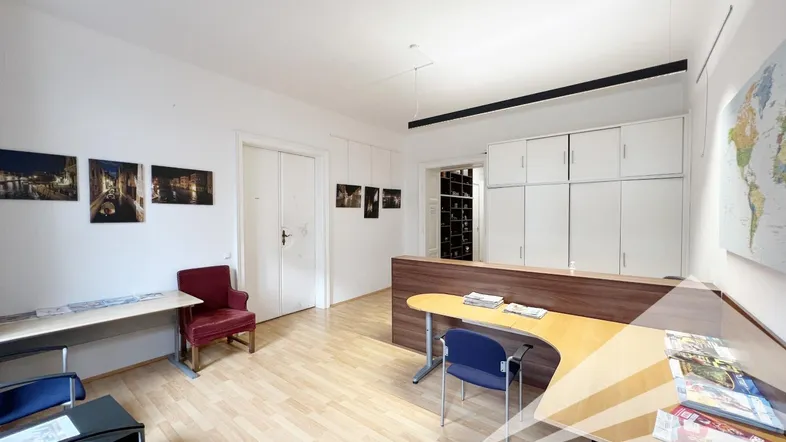 Geräumiges Büro mit hellem Holzfußboden, weißen Wänden und praktischen Einbauschränken für Stauraum.