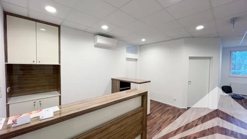 Empfangsbereich mit Holzoptik-Boden, Einbauschränken und Klimaanlage in einem modernen Büro.