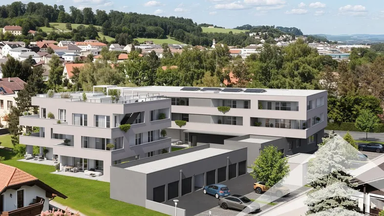 Moderne Wohnanlage mit mehreren Gebäuden, Tiefgarage und viel Grünfläche in hügeliger Umgebung.