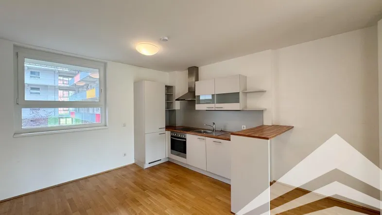 Helle, offene Küche mit Holzboden und integrierten Geräten, ideal für modernes Wohnen.