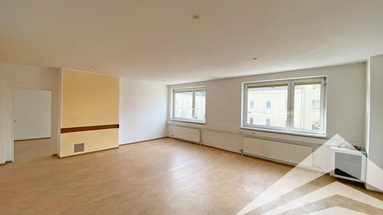 Geräumiger, leerer Büroraum mit großen Fenstern und hellem Bodenbelag, bereit zur individuellen Gestaltung.