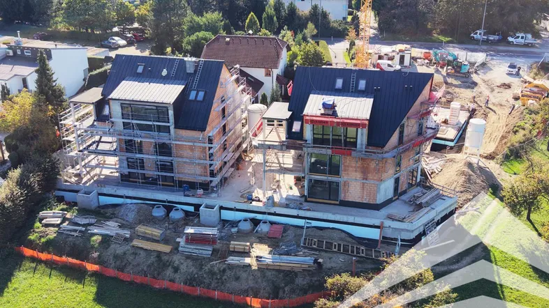 Luftaufnahme von zwei im Bau befindlichen Gebäuden mit Gerüsten und Baustelle.