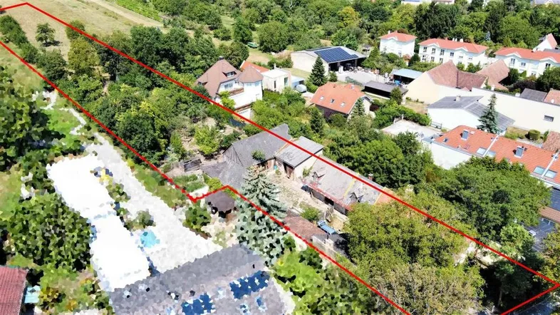 Luftaufnahme des Grundstücks mit roter Umrandung, umgeben von viel Grün und weiteren Häusern.