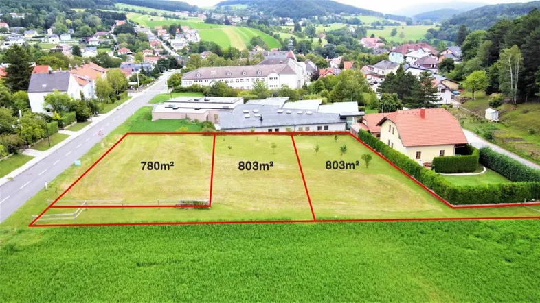 Luftaufnahme der Baugrundstücke mit roten Umrandungen und Flächenangaben in ländlicher Umgebung.