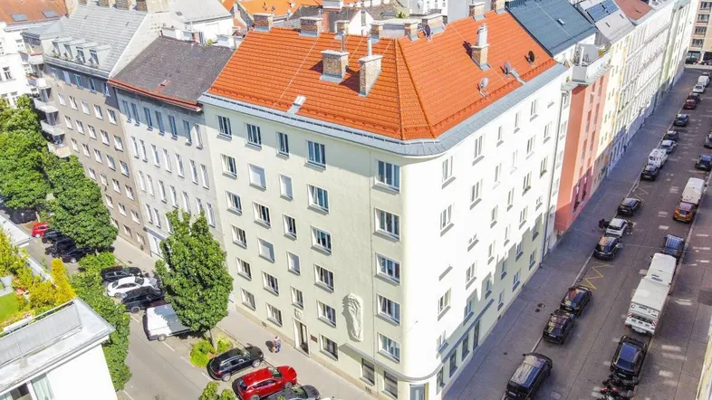Luftaufnahme eines Wohngebäudes mit rotem Satteldach und umliegenden Straßen.