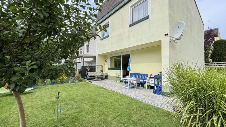 Geräumige Terrasse mit Gartenmöbeln und direktem Zugang zum gepflegten Rasenbereich des Hauses.