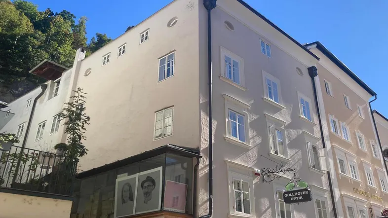 Historisches Gebäude mit traditioneller Fassade und modernen Elementen in einer städtischen Umgebung.
