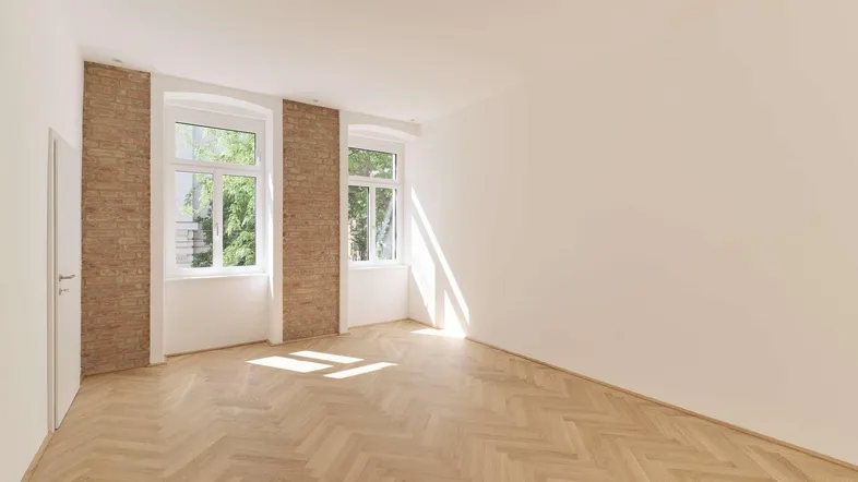 Helles Zimmer mit Fischgrätparkettboden, weißen Wänden und freigelegten Ziegelakzenten, durchflutet von Sonnenlicht.