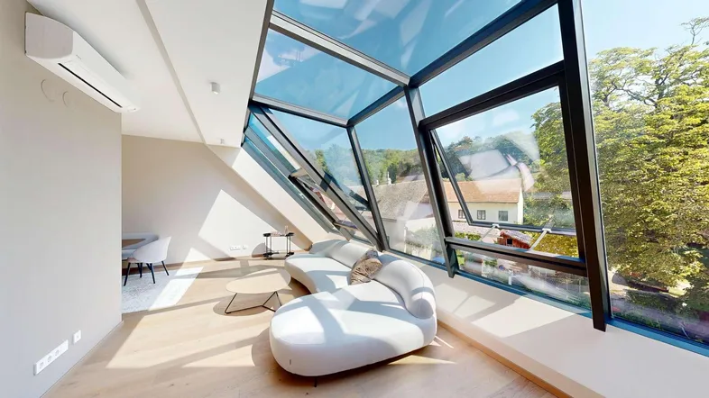 Helles Wohnzimmer mit moderner Einrichtung, großen Glasflächen und weitem Blick ins Grüne.