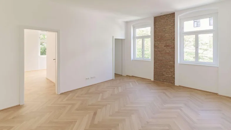 Helles, frisch renoviertes Zimmer mit elegantem Fischgrätparkett und hohen Decken.