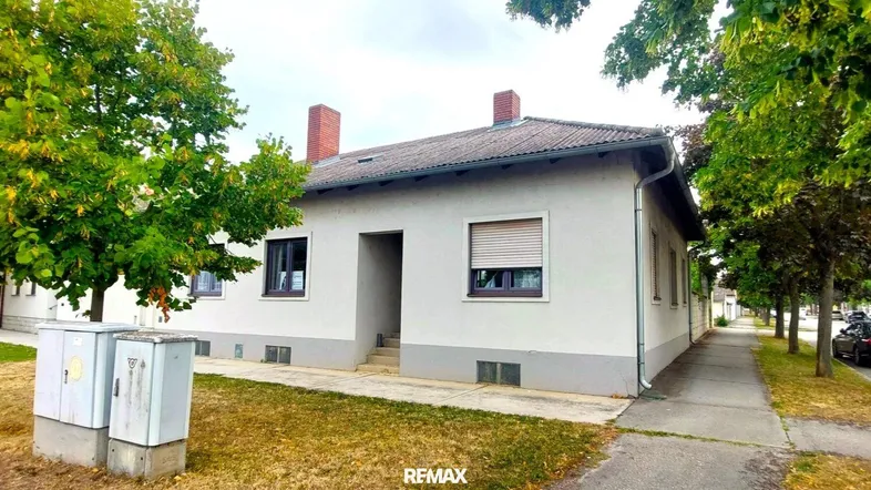 Einfamilienhaus mit schlichter Fassade, Rollläden und Vorgarten in einer ruhigen Wohngegend.