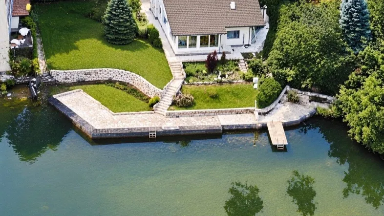 Luftaufnahme des Hauses mit direktem Zugang zum See und gepflegtem Gartenbereich.