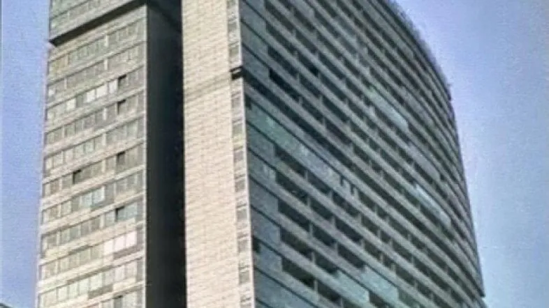 Modernes Hochhaus mit markanter Glasfassade und vielen Etagen in urbaner Umgebung.
