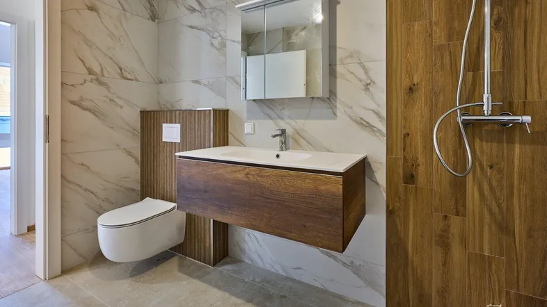 Elegantes Badezimmer mit schwebendem Waschtisch, begehbarer Dusche und hochwertigen Fliesen.